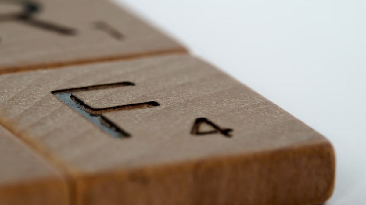 Macro shot of wooden Scrabble tiles with engraved letters and numbers.